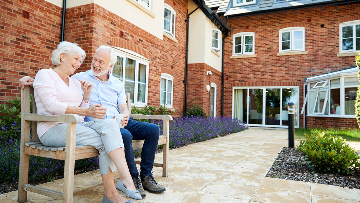 Markets-Assisted-Living-Woman-and-Man-Outside-on-Bench
